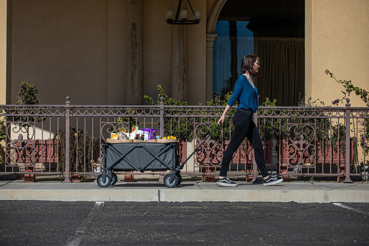 Person pulling a utility wagon filled with Vegas Golden Knights merchandise on a sidewalk