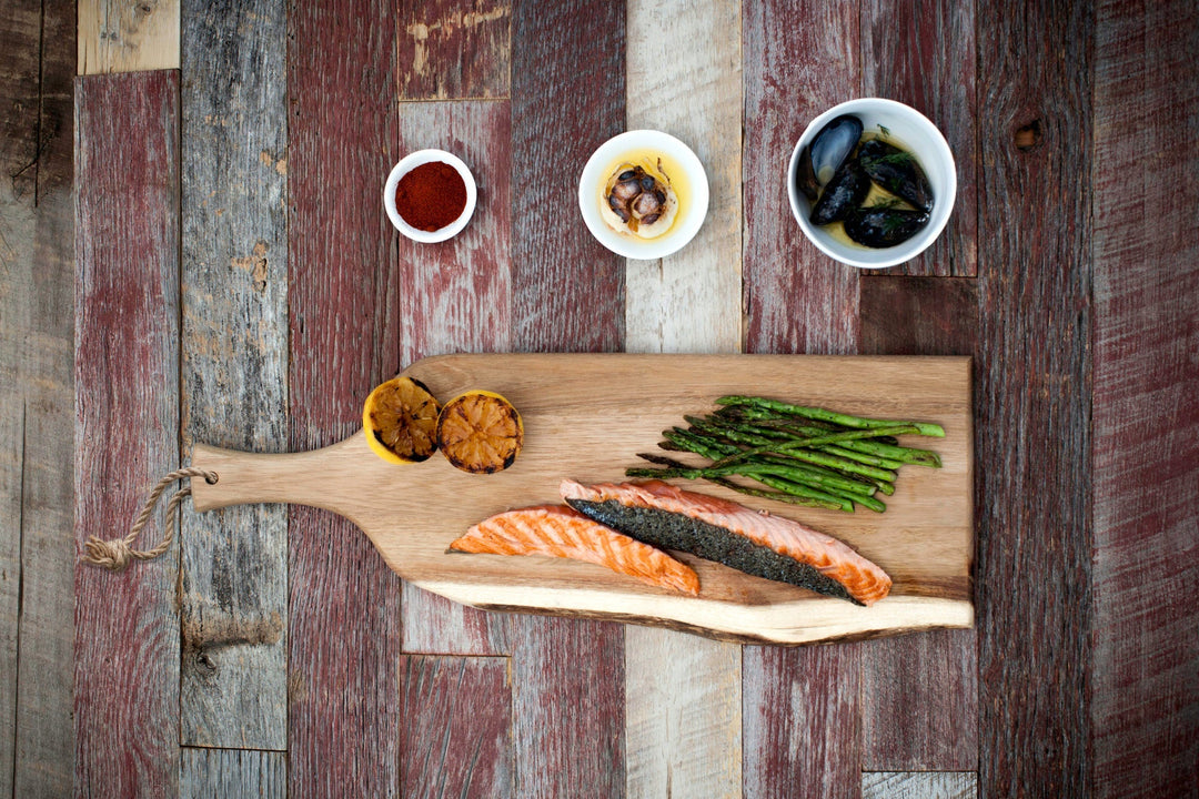 Wooden charcuterie board featuring salmon, asparagus, and grilled lemons for Vegas Golden Knights