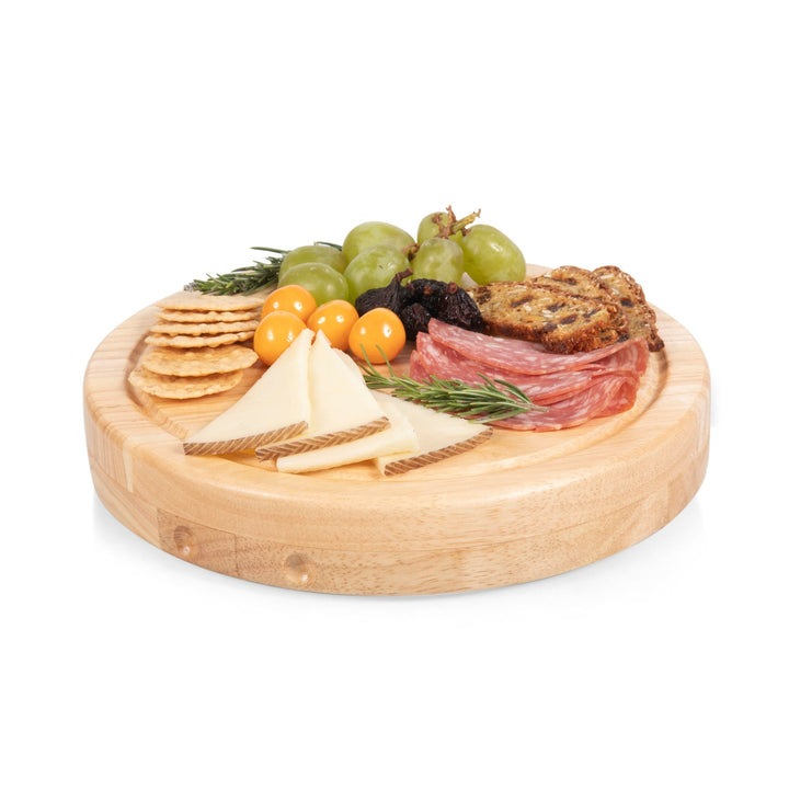 Circular wooden cutting board with meats, cheeses, fruits, and crackers on Circo Cheese set